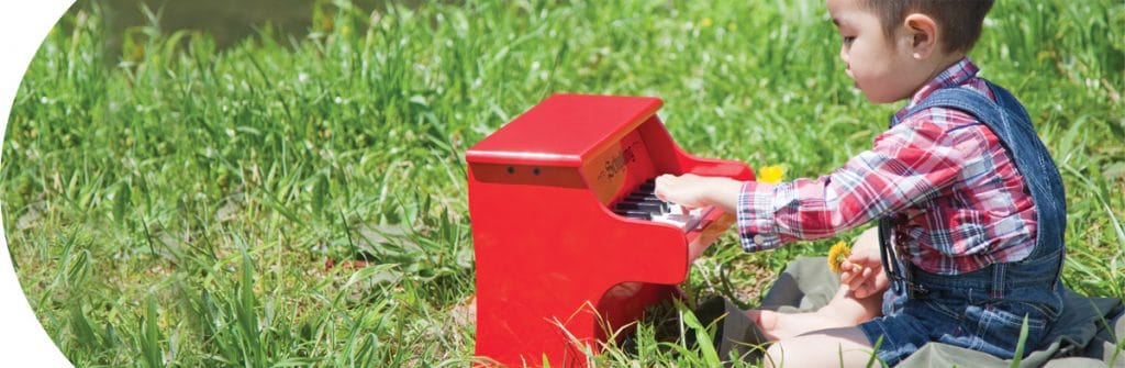 category-music Music - Boy in grass with Schylling Little Red Piano