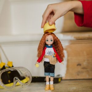 Lifestyle shot of a child placing hard hard on Young Inventor Lottie doll