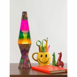 14.5” LAVA® Lamp Colormax PaintBall – White/Tricolor on a table with a smiley face pencil cup, notebook, and giraffe figures