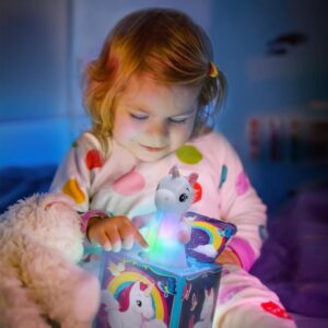 Toddler in pajamas holding Pop & Glow light up Unicorn Jack in the Box