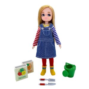 Garden Time Lottie - Doll standing with blonde hair, denim overalls dress, striped shirt. She's standing next to two handheld garden tools, seed boxes, and a green watering can
