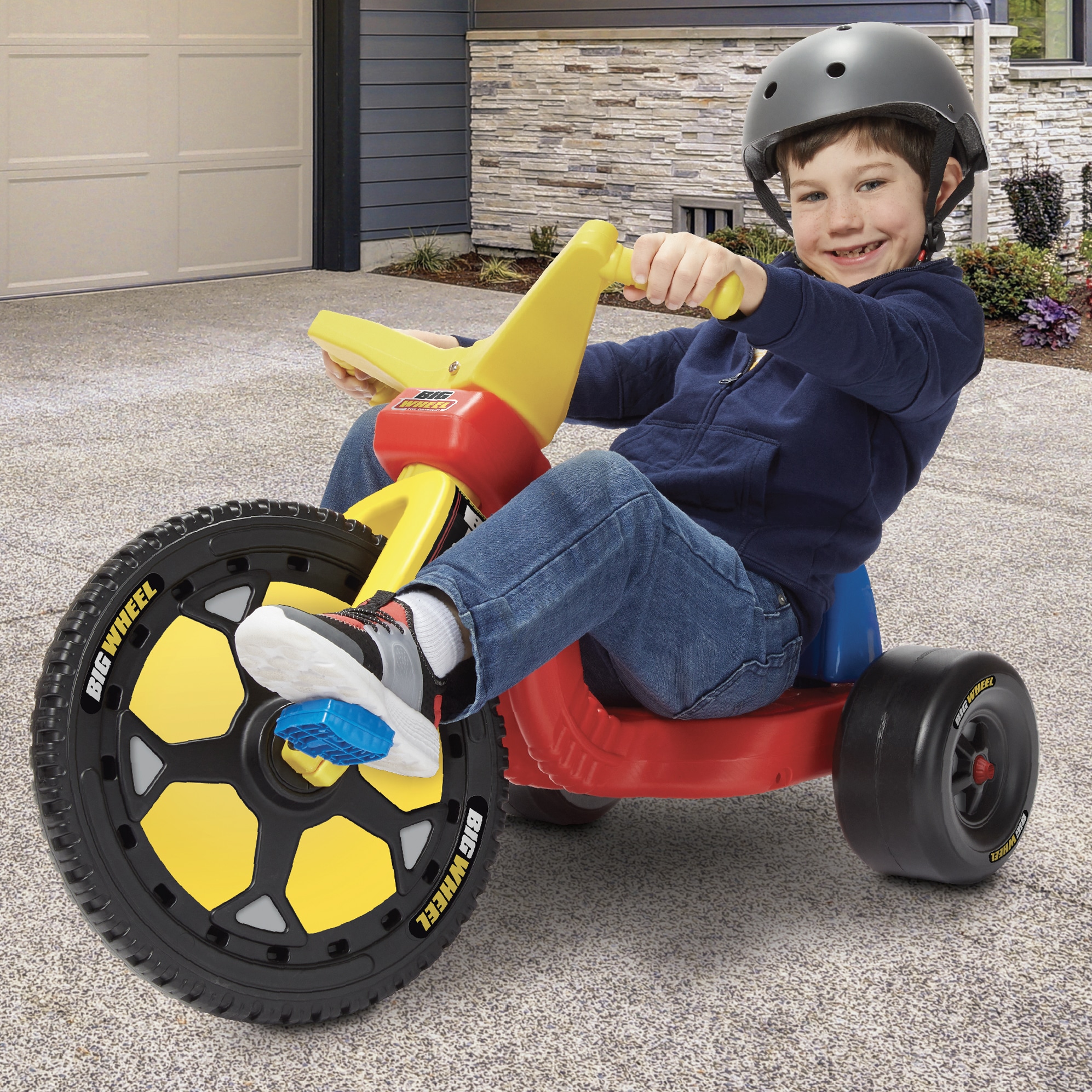 Boy with helmet on 16 inch Speedster Big Wheel