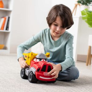 Lifestyle shot of a child playing with the Tonka Chuck My Talking Truck on the floor