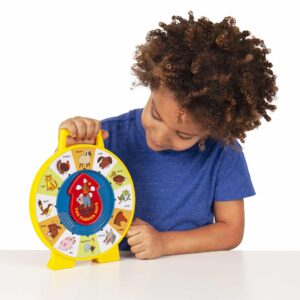 Lifestyle shot of boy looking at the Fisher-Price See N Say on a table top