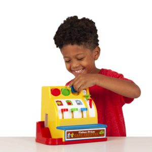 Lifestyle shot of boy putting coins in the Fisher-Price Cash Register