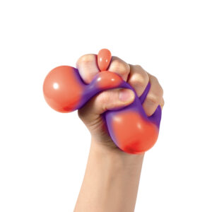 A hand tightly gripping a squishy, bi-colored sensory toy. The toy is primarily orange with a purple gradient. The background is plain white, highlighting the texture and colors of the sensory toy.