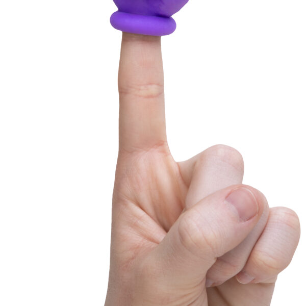 A hand on a white background with one finger pointing up and a purple peace sign finger topper on top.