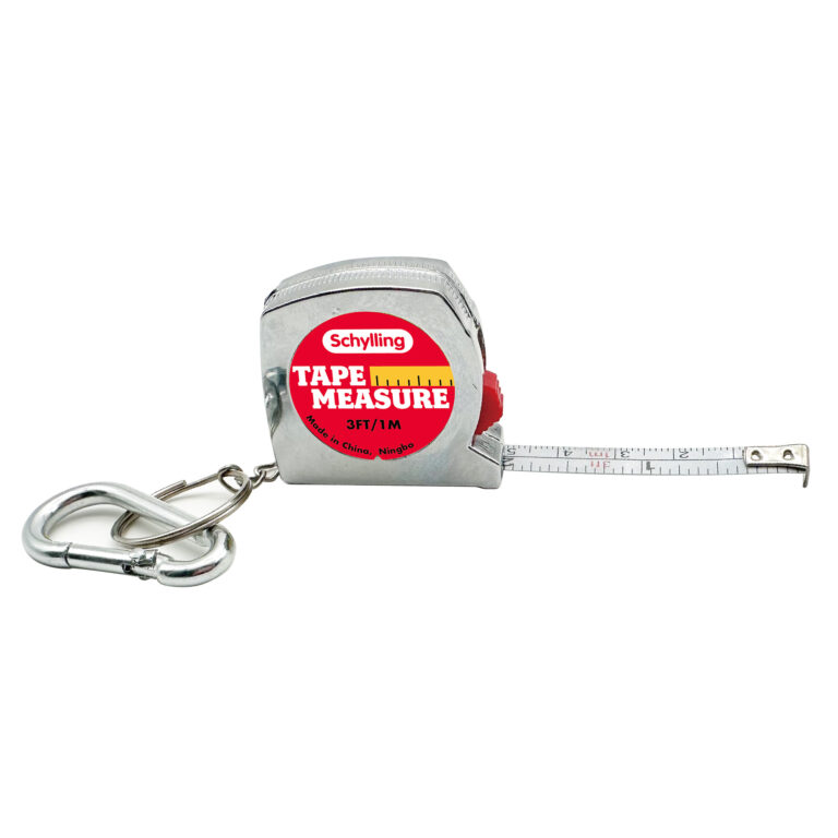 A small tape measure labeled "Schylling Tape Measure" is shown with a metal carabiner attached. The tape is partially extended, displaying measurements in both inches and centimeters. The casing is metallic with a red and yellow label.