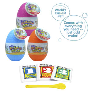 Three packets, numbered 1, 2, and 3 from left to right. There is a small yellow Sea-Monkeys spoon laying in front of the packets. There are two callouts in circles. One reads "World's Easiest Pet!" and the other reads "Comes with everything you need - just add water!"