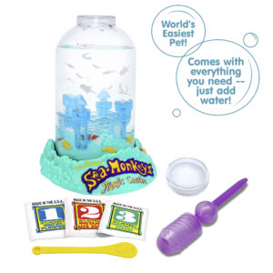 Three packets, numbered 1, 2, and 3 from left to right are vivble in front of the Magic Castle aquarium. There is a small yellow Sea-Monkeys spoon laying in front of the packets, and a purple pipette and clear circle magnifyer next to the spoon. There are two callouts in circles. They read "World's Easiest Pet!", and "Comes with everything you need -- just add water!"